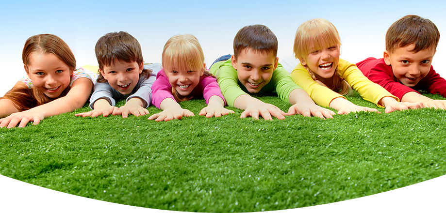 Six happy diverse children lying on green grass smiling
