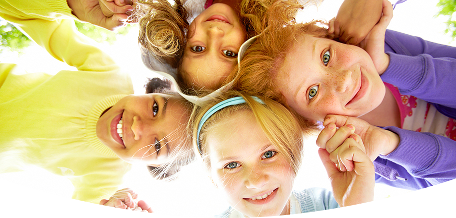 Four cheerful children in circle looking down at camera